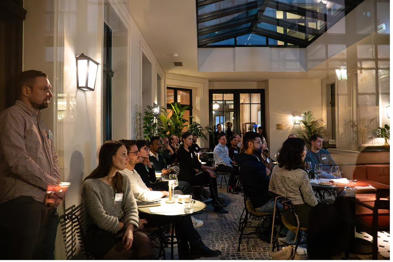 A light-filled museum room arranged for an executive roundtable